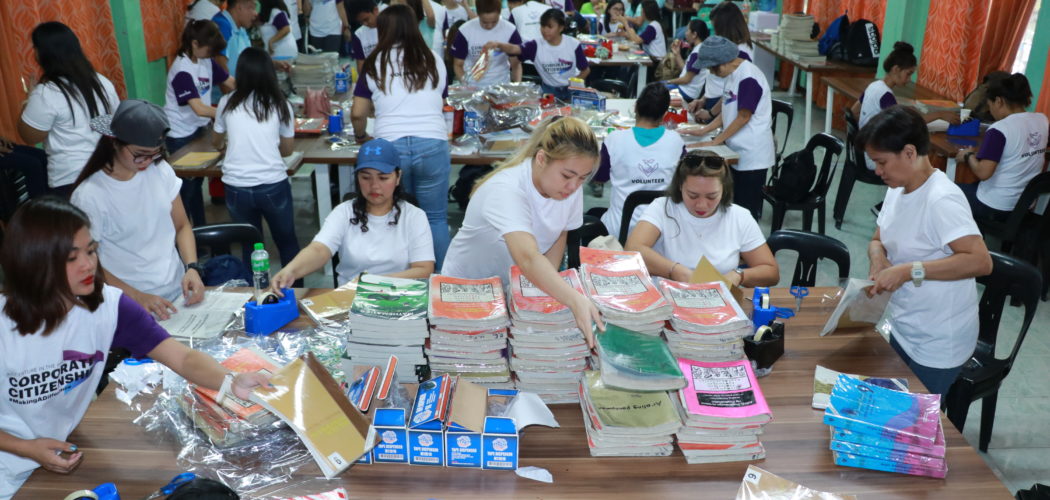 Employee-volunteers of Accenture and Sycip Law cover books during PBSP's Ready for School activities in Taguig National High School.