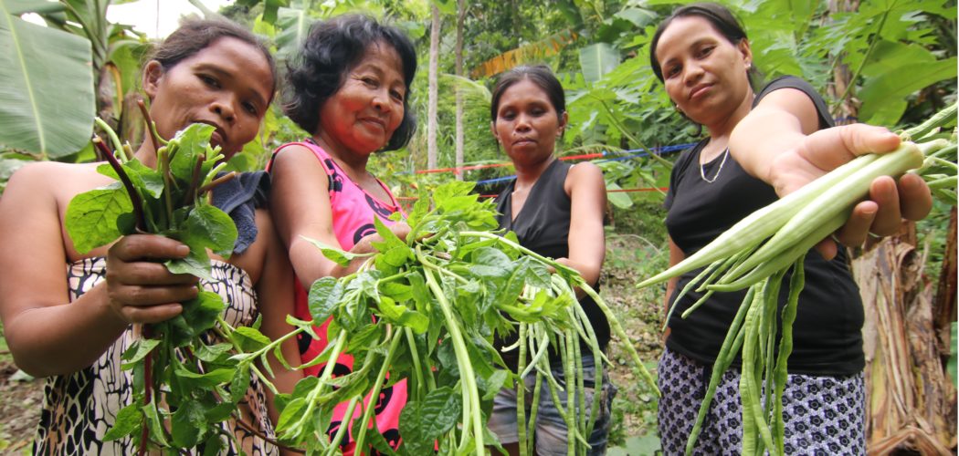 Mothers in Buhisan, Cebu show off their newly-harvested vegetables that they planted in their own backyard gardens to help sustain the healthy meals given to their children.